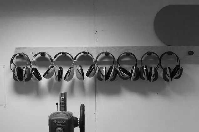 Hearing protection ear muffs hung on the wall. Photo.